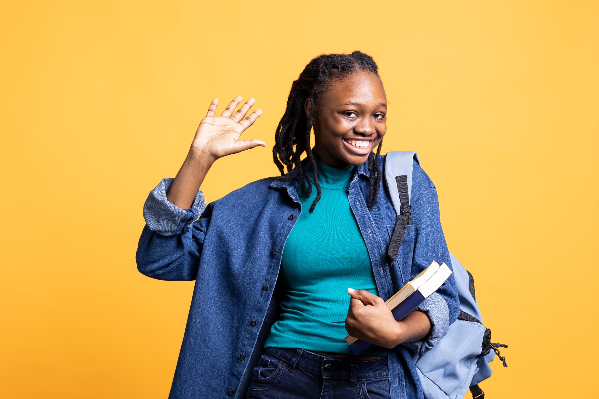 Smiling Ugandan member of a church-linked SACCO waving, holding books